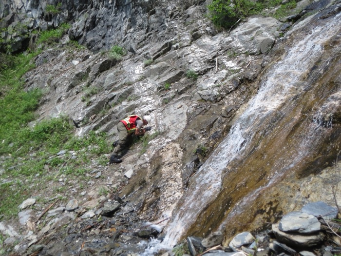 Sampling bedrock beside a waterfall on the Rare One Project